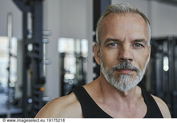 Mature man with grey hair and beard in gym
