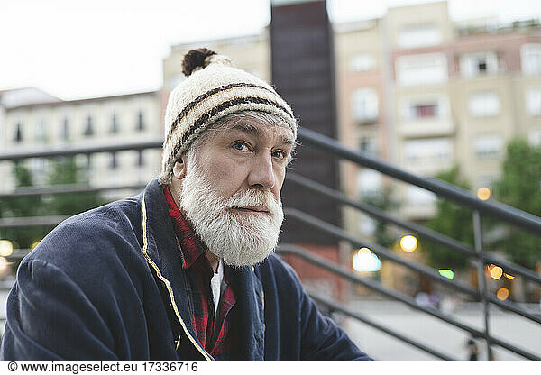 Mature man with white beard wearing knit hat