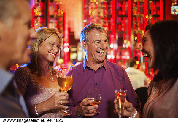 Mature men and women enjoying drinks in nightclub