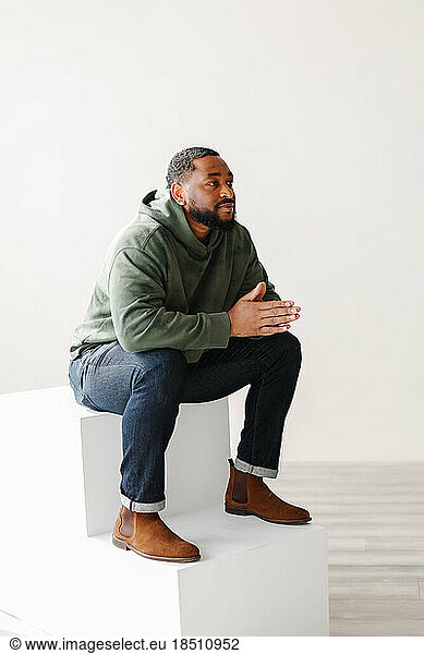 mature stylish Black man sitting on steps indoor