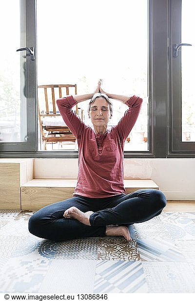 Mature woman doing yoga at home