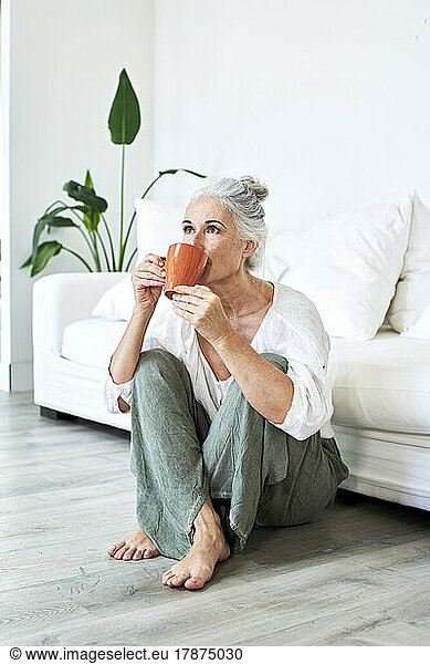 Mature woman drinking coffee sitting at home