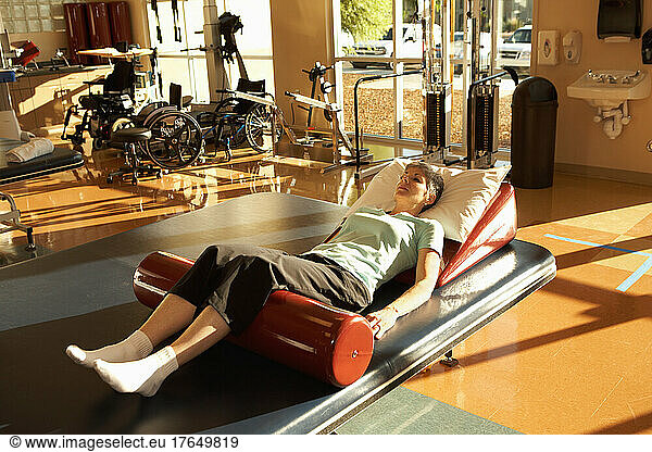 Mature woman exercising in rehab gym