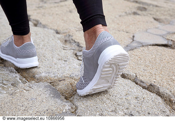 Mature woman exercising  running  outdoors  focus con feet