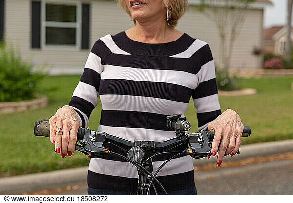Mature woman in her seventies enjoying a day outside on her bike.