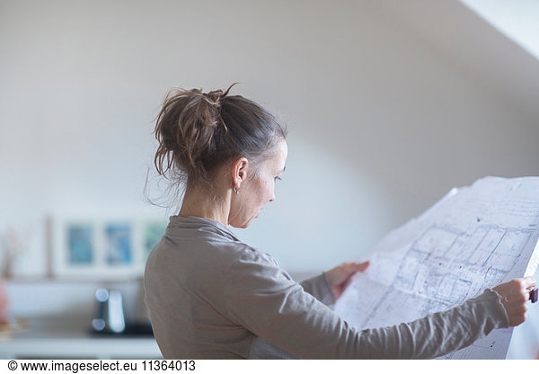 Mature woman looking at blueprints