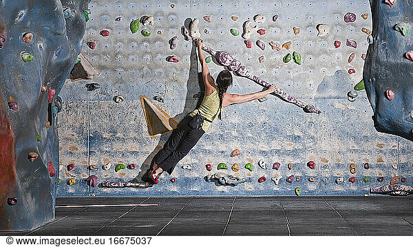 mature woman practising at indoor climbing wall in the UK