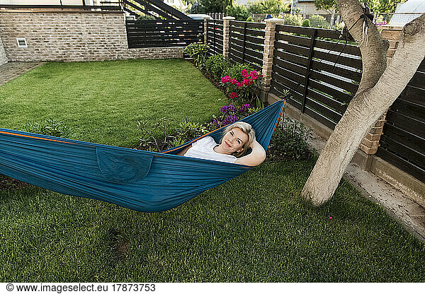 Mature woman relaxing on hammock in garden