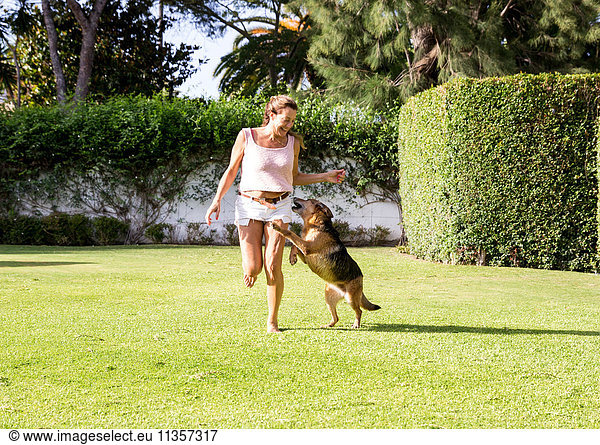 Mature woman running in park with dog
