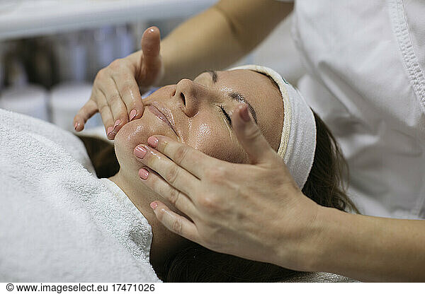 Mature woman taking face massage in salon
