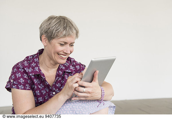 Mature woman using digital tablet  smiling