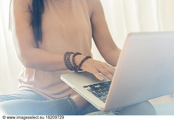 Mature woman using laptop during yoga session at home