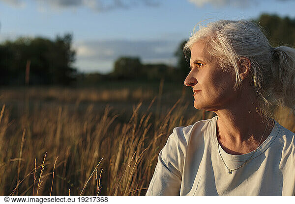 Mature woman with grey hair at sunset