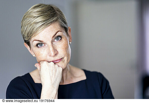 Mature woman with hand on chin