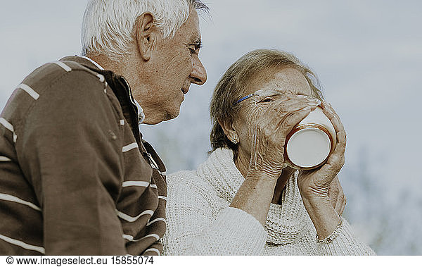 Mature woman with husband drinking tea or coffee
