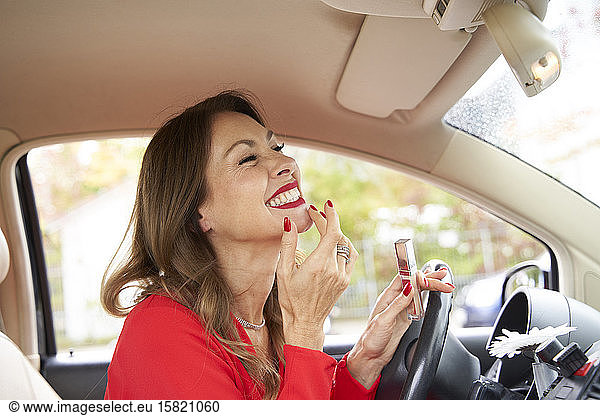 Mature woman with red lipps and nails in car
