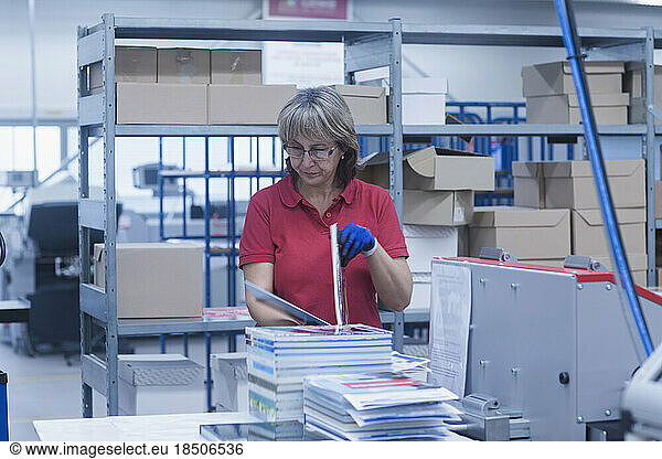 Mature woman working in books printing industry  Bremgarten  Hartheim am Rhein  Baden-Wuerttemberg  Germany