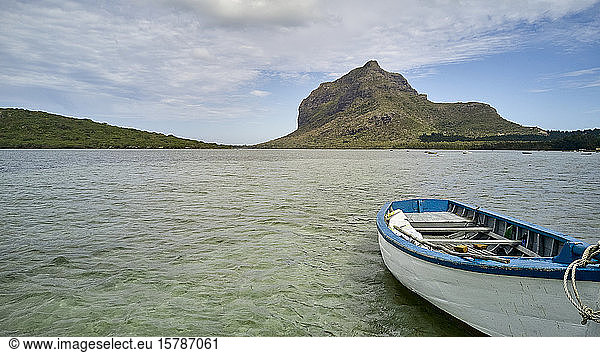 Mauritius  Leeres  im Wasser schwimmendes Ruderboot mit der Halbinsel Le Morne Brabant im Hintergrund