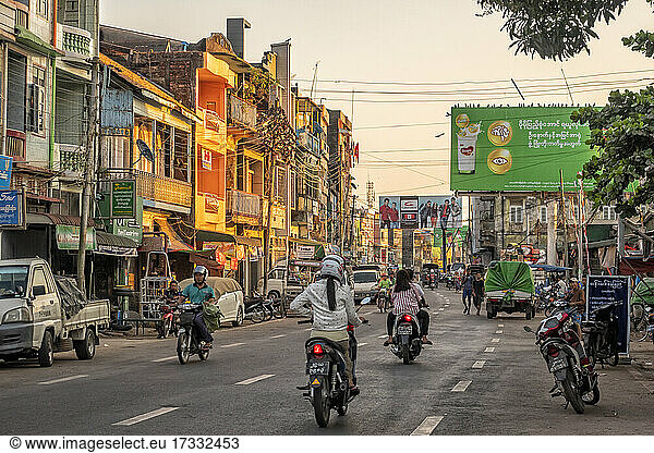 Mawlamyine  Ladenfronten und Verkehr auf der Straße bei Sonnenuntergang