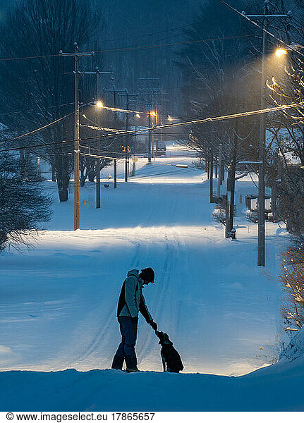 Me and my dog on a snowy street lit avenue