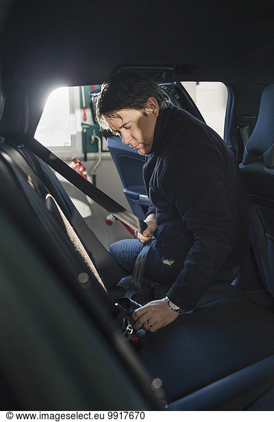 Mechanic repairing car seat belt in auto repair shop