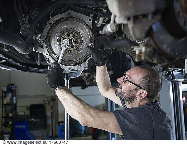 Mechanic repairing car wheel in auto repair shop