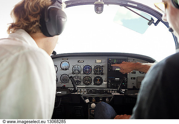 Mechanics examining cockpit of airplane