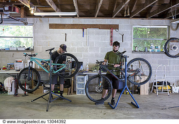 Mechanics repairing mountain bikes in bicycle shop