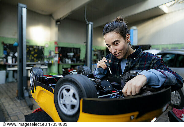 Mechanikerin repariert Spielzeugauto in der Werkstatt
