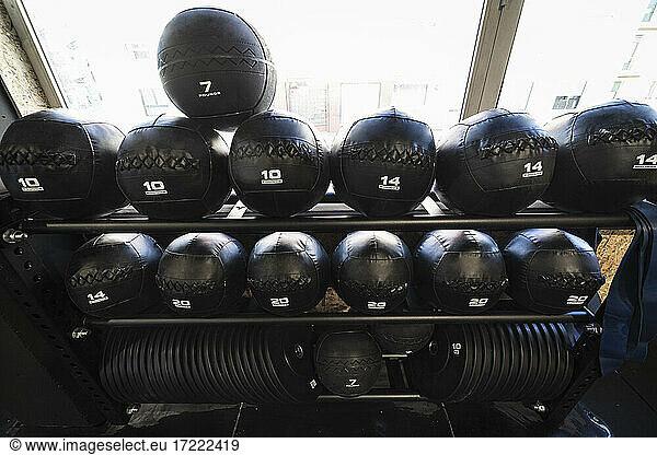 Medicine balls and weights on gym rack