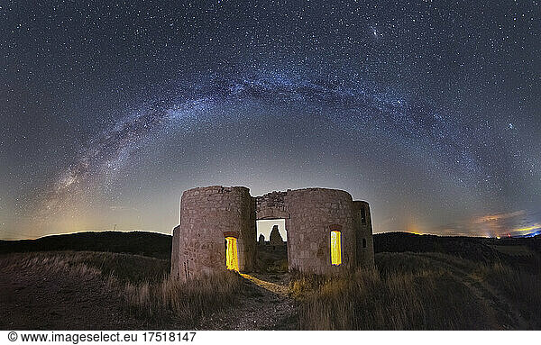Medieval castle under stars sky with Milky Way arch
