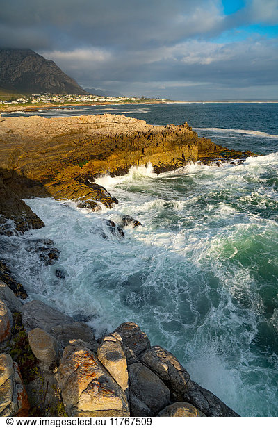 Meereslandschaft mit stürmischer See und Felsen in der untergehenden Sonne am Sievers Point  Hermanus  Südafrika  Afrika