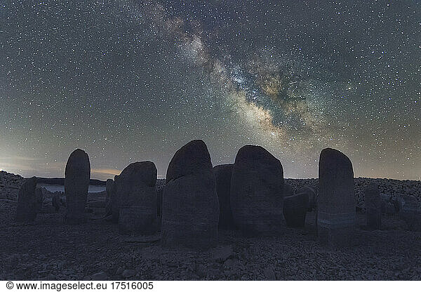 Megalithic landmark under stars sky with Milky Way close to lake lake