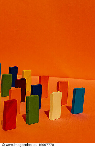Mehrfarbiger rechteckiger Spielzeugblock vor orangefarbenem Hintergrund