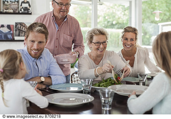 Mehrgenerationen-Familie beim gemeinsamen Mittagessen zu Hause