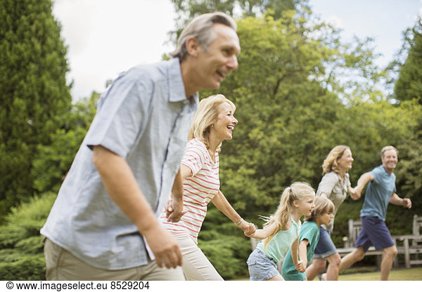 Mehrgenerationen-Familie beim Händchenhalten und Laufen