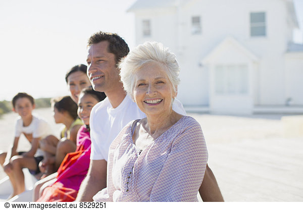 Mehrgenerationen-Familie lächelt vor dem Strandhaus