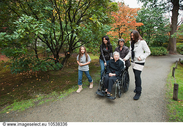 Mehrgenerationen-Familie mit Seniorin im Rollstuhl