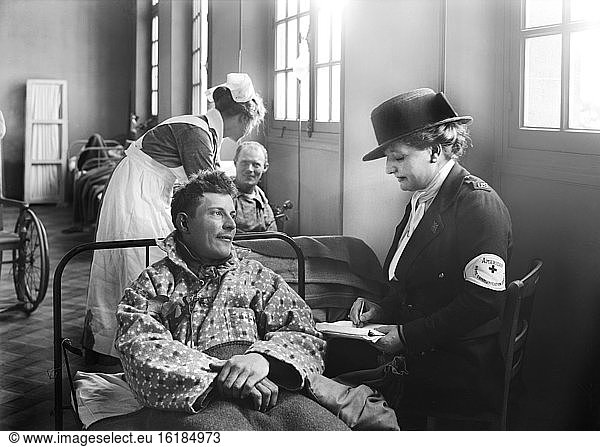 Member of the American Red Cross Home Communication Service writing a letter for American Soldier in Corridor in the American Military Hospital No. 1 Neuilly  France  Lewis Wickes Hine  American National Red Cross Photograph Collection  June 1918