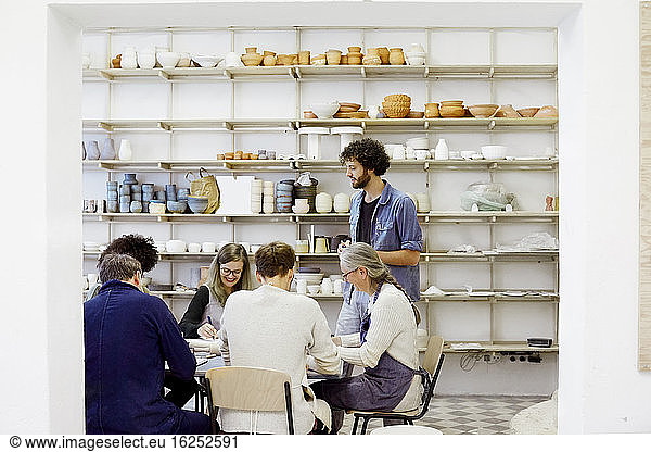 Men and women learning pottery in art studio