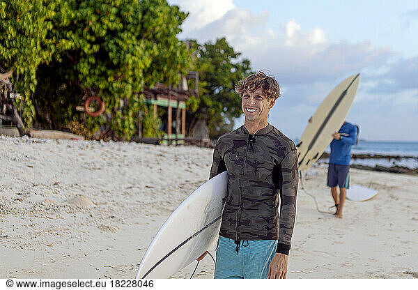 Men carrying surfboard walking at the beach