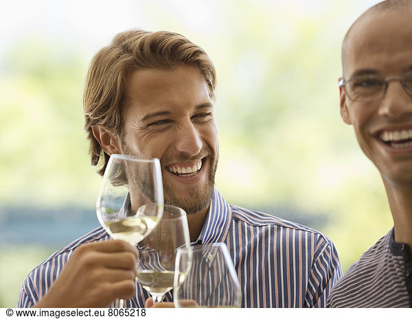 Men drinking wine together indoors