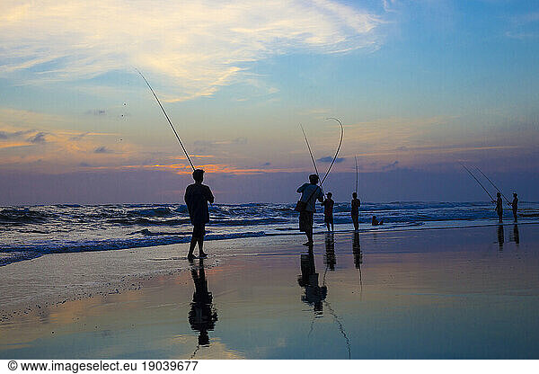 Men fish at sunset. Bali. Indonesia.
