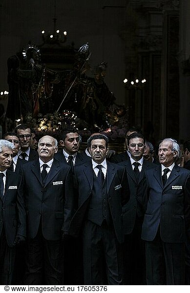 Men from the metalsmiths brotherhood  elegantly dressed for the Good Friday procession in the Cathedral door with their statue in the background  in Trapani  Sicily  Italy  Europe