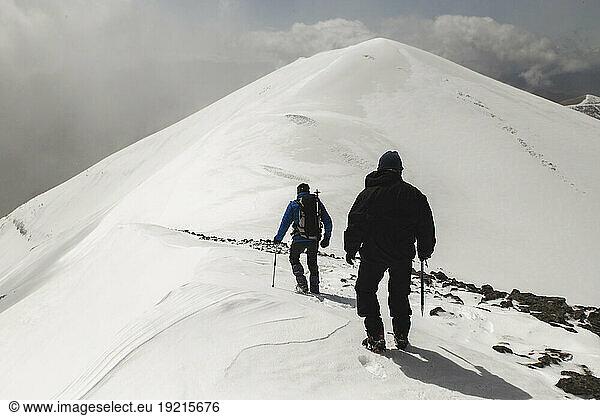 Men hiking on snowcapped mountain