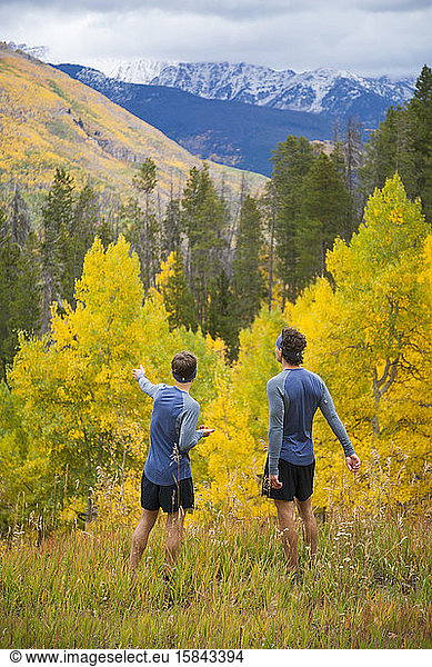 Men on trail run enjoy view of aspen and mountains in Vail  Colorado