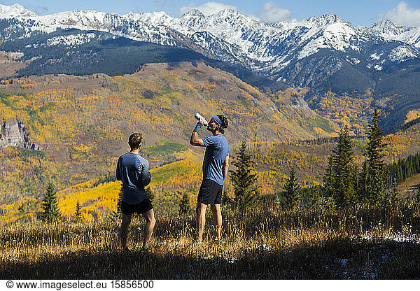 Men on trail run look at Gore Range mountains from Vail  Colorado