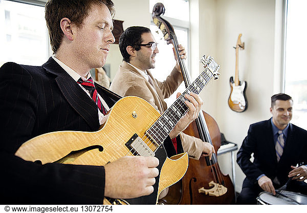 Men playing musical instruments in studio