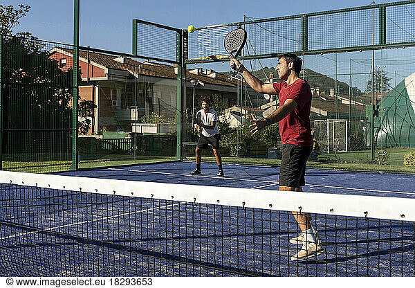 Men playing paddle tennis at sports court