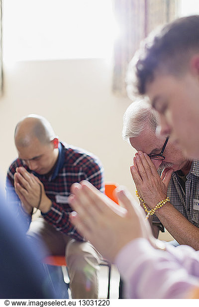 Men praying with prayer beads in prayer group